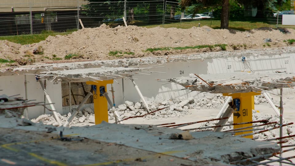 Demolished concrete slabs held up by yellow shoring posts, from the Registon Building film