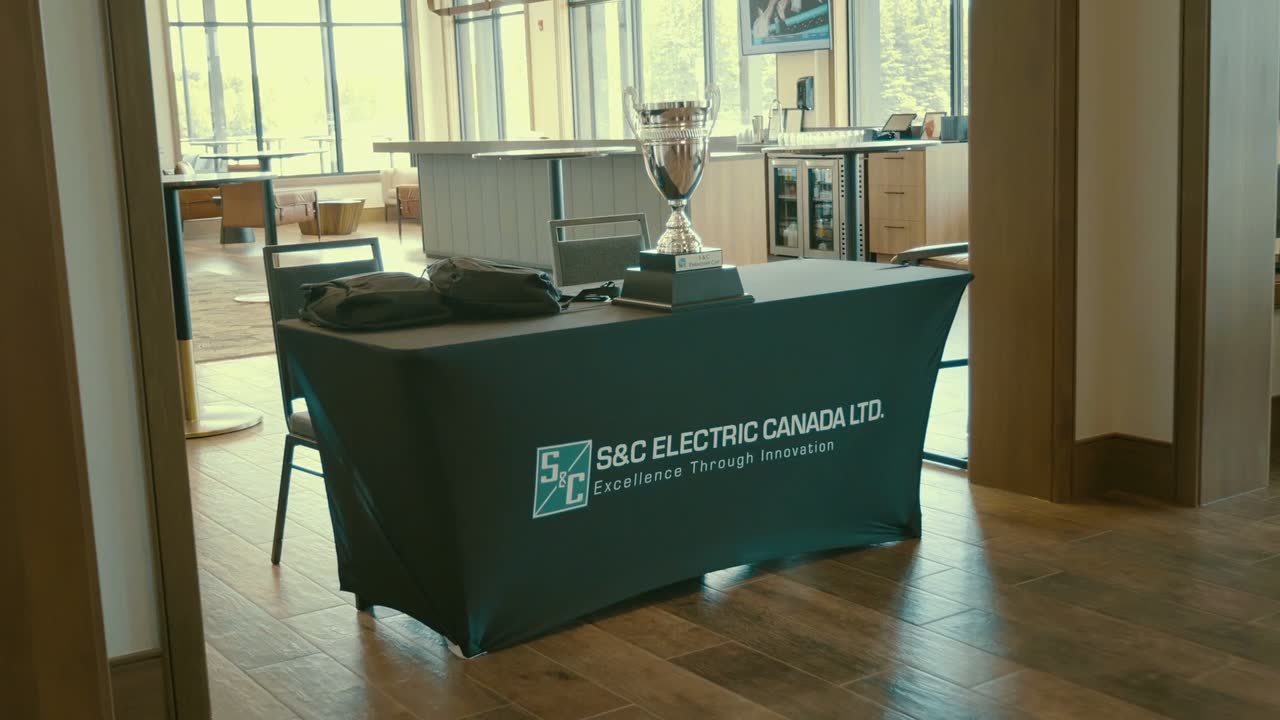 An S&C Electric Canada branded table with a trophy on it, at the company event